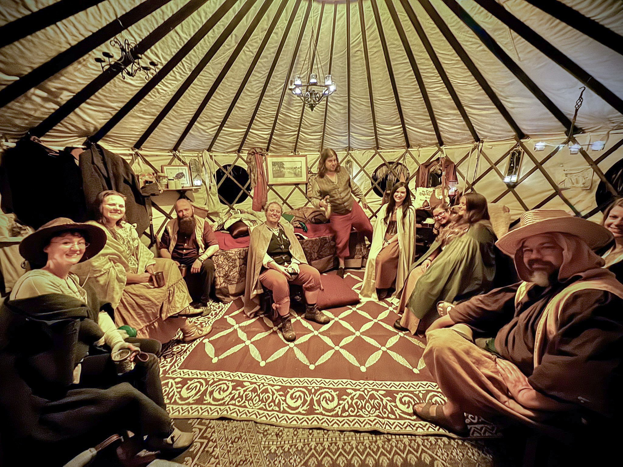 Festival-goers in costume gathered together inside a lantern-lit ThatchTop Burrow