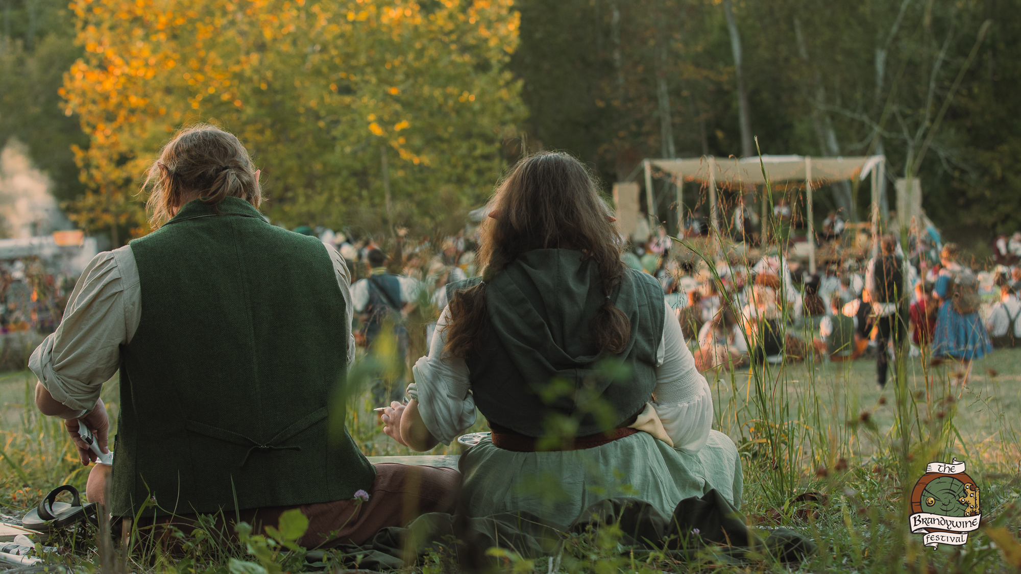 Two friends sitting together watching the festival at golden hour