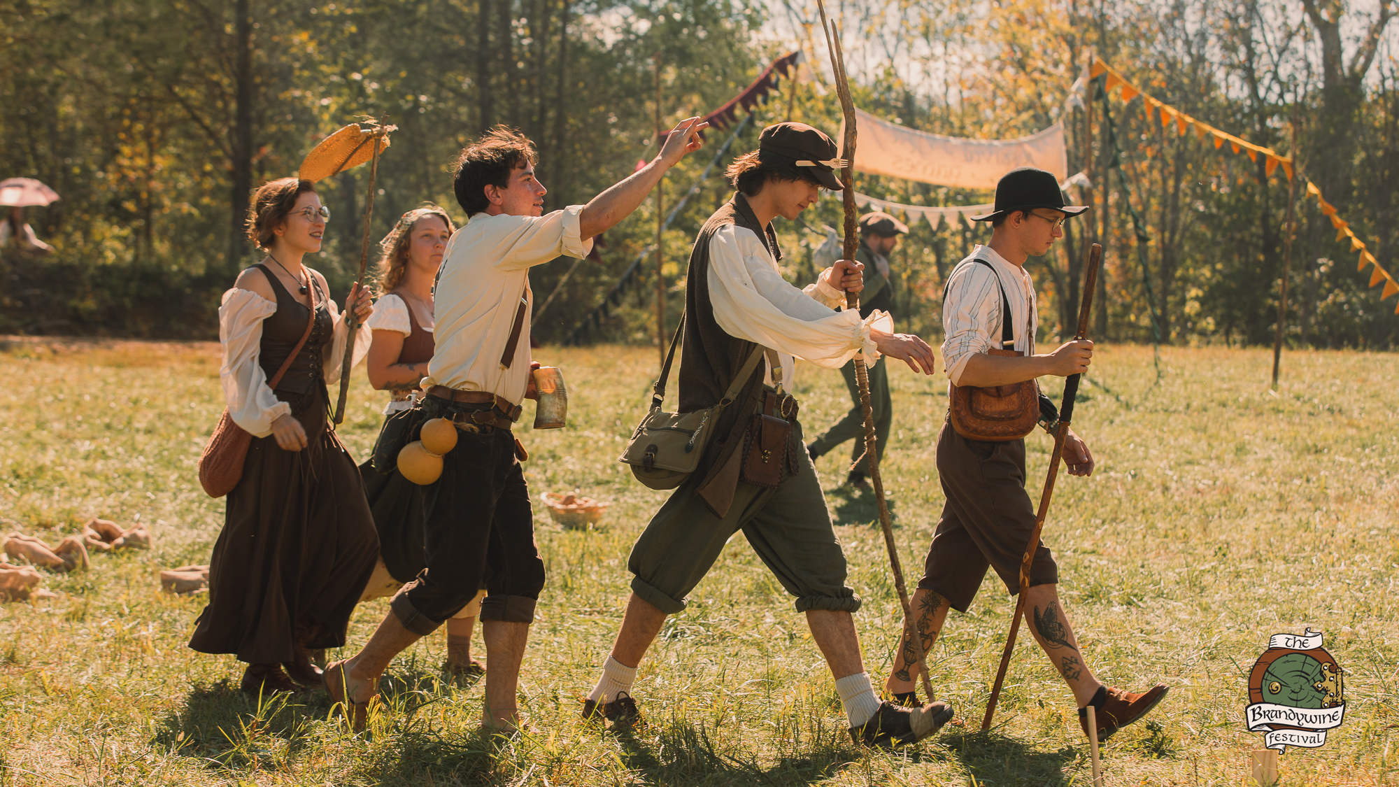 A merry band wandering the fields with banners